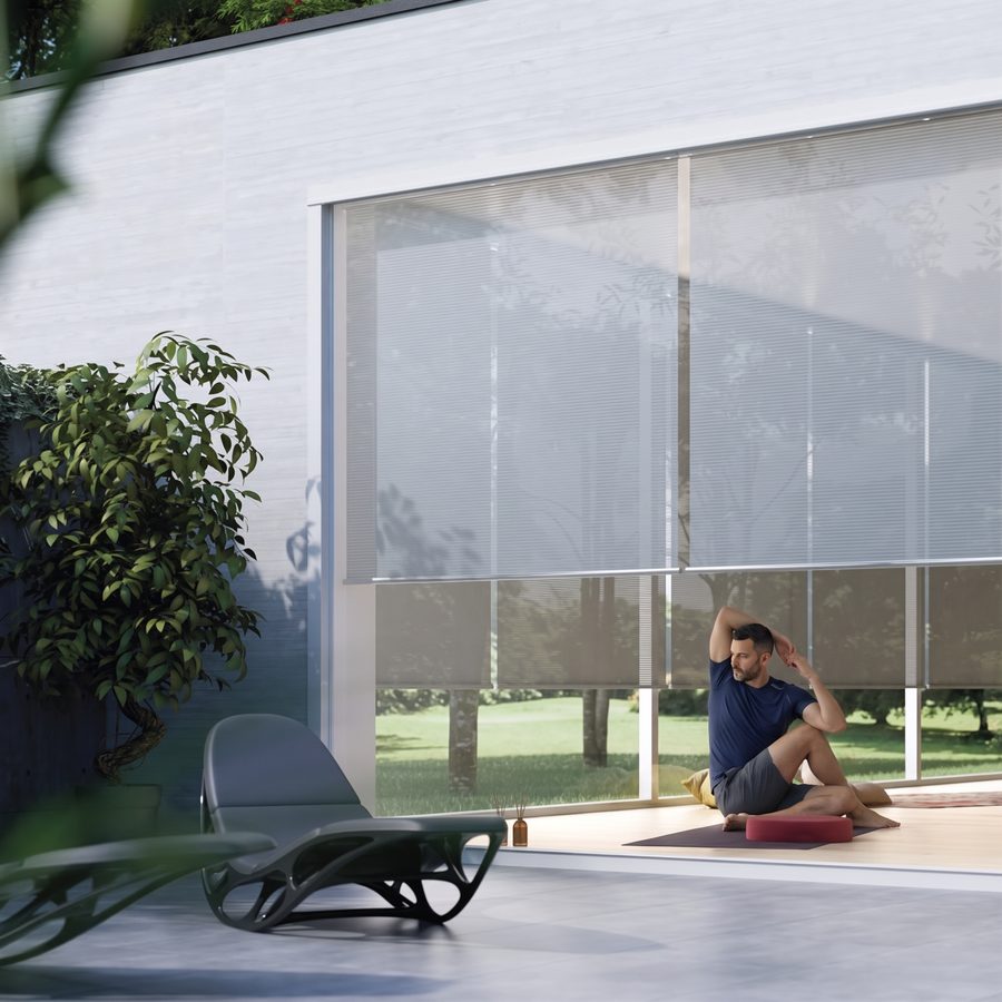 A man stretching on a patio beside motorized exterior shades